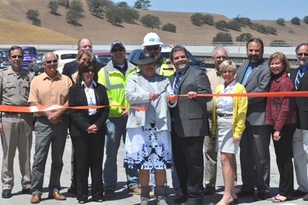 Fix 46 Committee Chairperson Mary Chambers leads the crowd in a ribbon cutting ceremony signifying the official completion of the bridges.