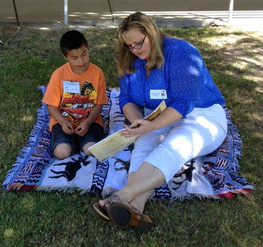 Student Alejandro Ibarro enjoys a story with Trina Nicklas.