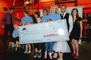 Members of Parents for Joy receive a check for $5,000 from Give Fitness Health Club owners Josh Donovan and Matt Holgiun.