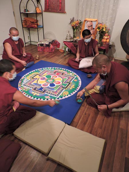 The monks lay the finishing touches on the mandala.