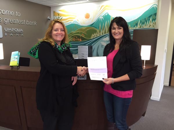 Umpqua Bank's Assistant Vice President of the Central Coast Agriguclture and Commercial Banking Center Ashley Ogden presents the donation to Manager of Community Engagement for Girl Scouts of California's Central Coast Laura Romano.