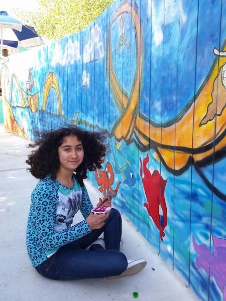 Student works on mural.