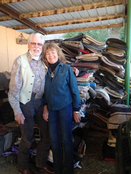 Dr. Gordon and wife Lu stand next to stacks of donated saddle pads waiting to be shipped to Haiti.
