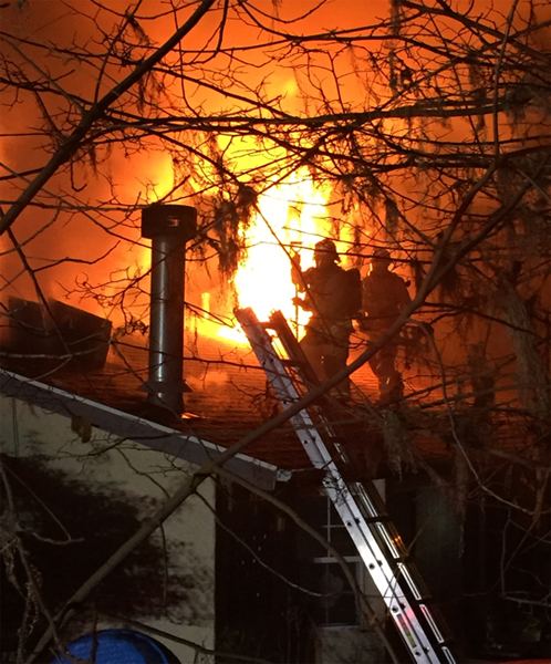 Firefighters exiting the roof after cutting a ventilation hole to contain the forward spread of the fire in the attic space. Photo and video credit to Atascadero Police Department.