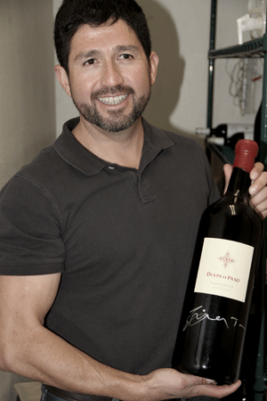 Enrique Torres holds one of the 3 liter bottles of his first vintage that he will open at the opening of the tasting room in March. Photo by Stephanie Austin