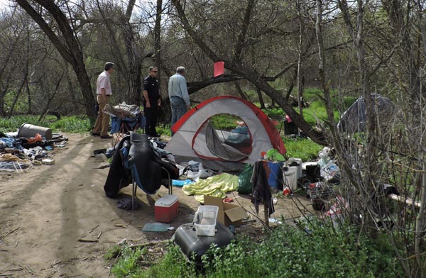Mayor Steve Martin and Police Lieutenant Ty Lewis escort a reporter through one of the encampments.