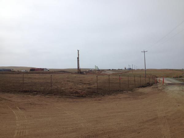 Photo of pile driving equipment and concrete work for abutment of new bridge.