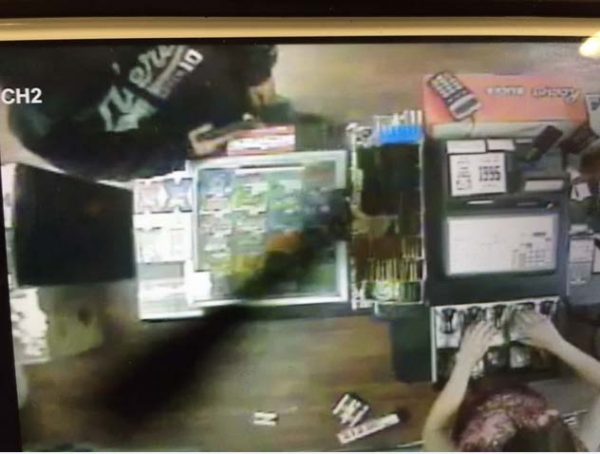 Partial photo of suspect showing sweatshirt and handgun.