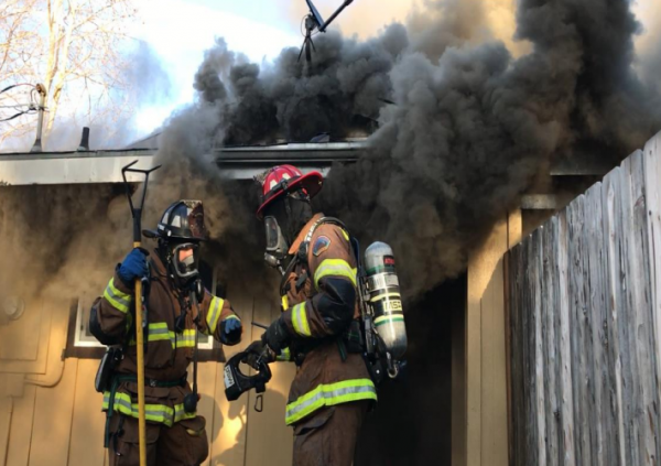 Firefighters preparing to enter the residence utilizing a thermal imaging camera to aid in locating the main body of the fire.