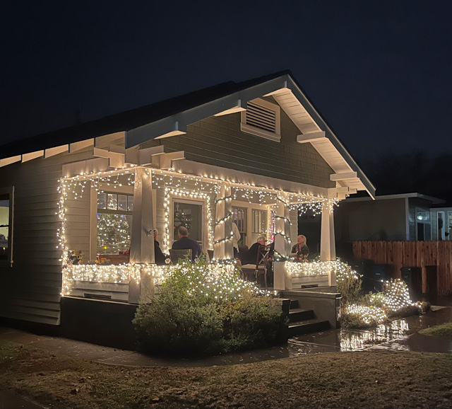 People gather on porches during the Vine Street Christmas Victorian Showcase