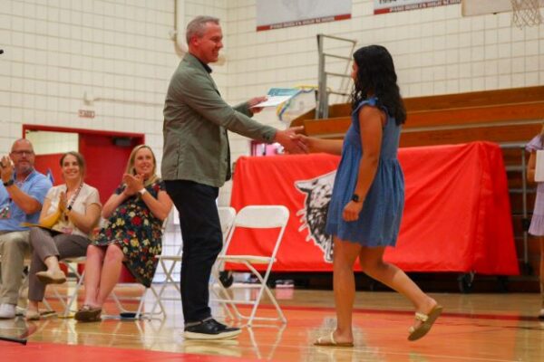 Below image Joel Peterson, PRWCAF executive director congratulating recipient Ellie Chavez. Photo courtesy of Chloe Van Pelt, Crimson Magazine.