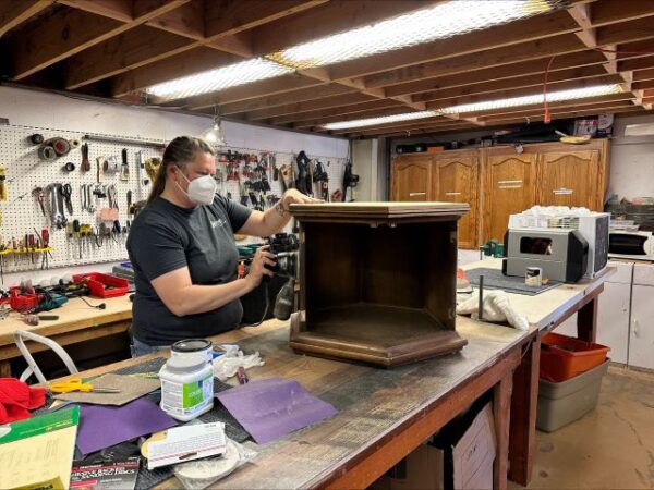 Photo caption: Habitat SLO ReStores Manager Stephanie Wright sands a side table at the Paso Robles ReStore.