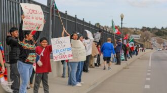 Community members gather at busy intersection to voice opposition