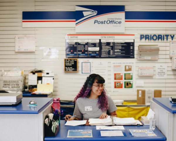 Worker at an NCI Affiliates post office counter